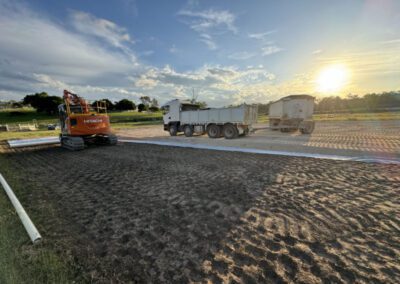 Construction site with excavator and truck during sunset